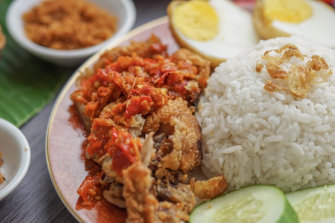 Tacho com arroz solto, pedaços de frango e cor escura do molho pardo