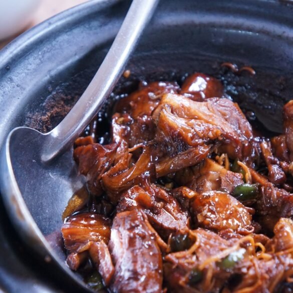 Travessa com pedaços de carne de porco frita, castanhas e tripa enfarinhada